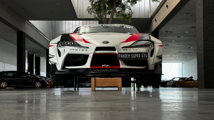 Ein weißer Sportwagen steht in einem modernen Ausstellungsraum.