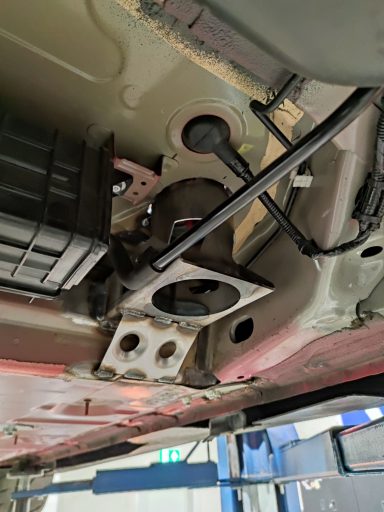 Blick auf das Unterboden eines Fahrzeugs, mit sichtbaren Komponenten und Halterungen.