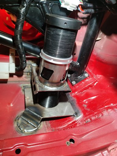Luftfederungssystem in einem Fahrzeugboden, Metallhalterung sichtbar.